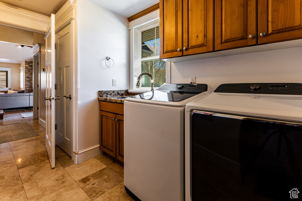 Washroom featuring cabinet space, healthy amount of natural light, and washing machine and dryer