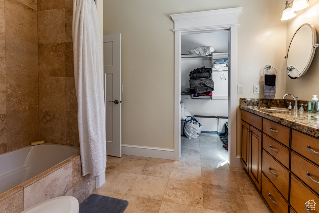 Full bath featuring vanity, tiled shower / bath combo, and tile patterned flooring