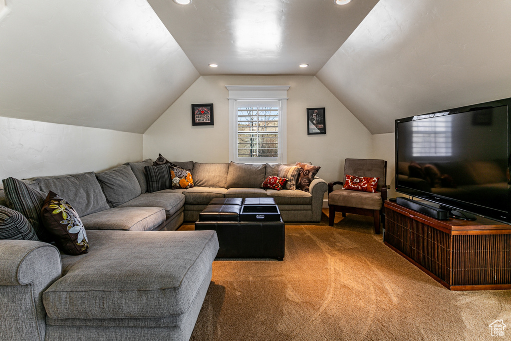 Carpeted living room with lofted ceiling and recessed lighting