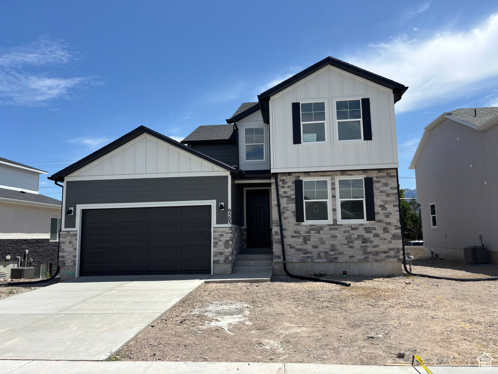 View of front of home featuring a garage, board and batten siding, and concrete driveway