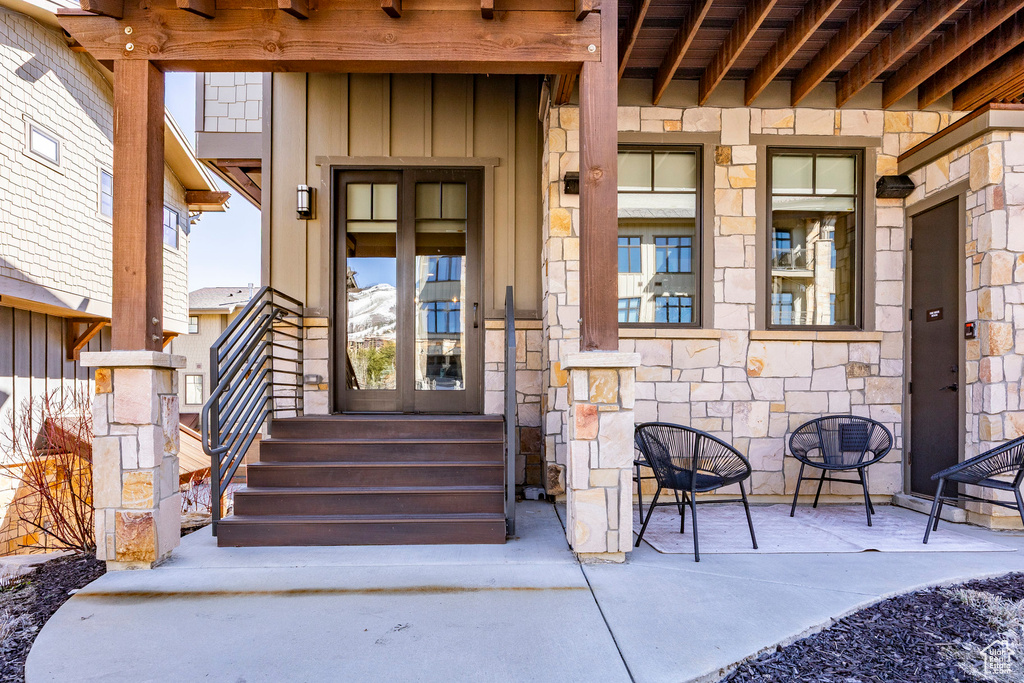View of exterior entry featuring stone siding and board and batten siding