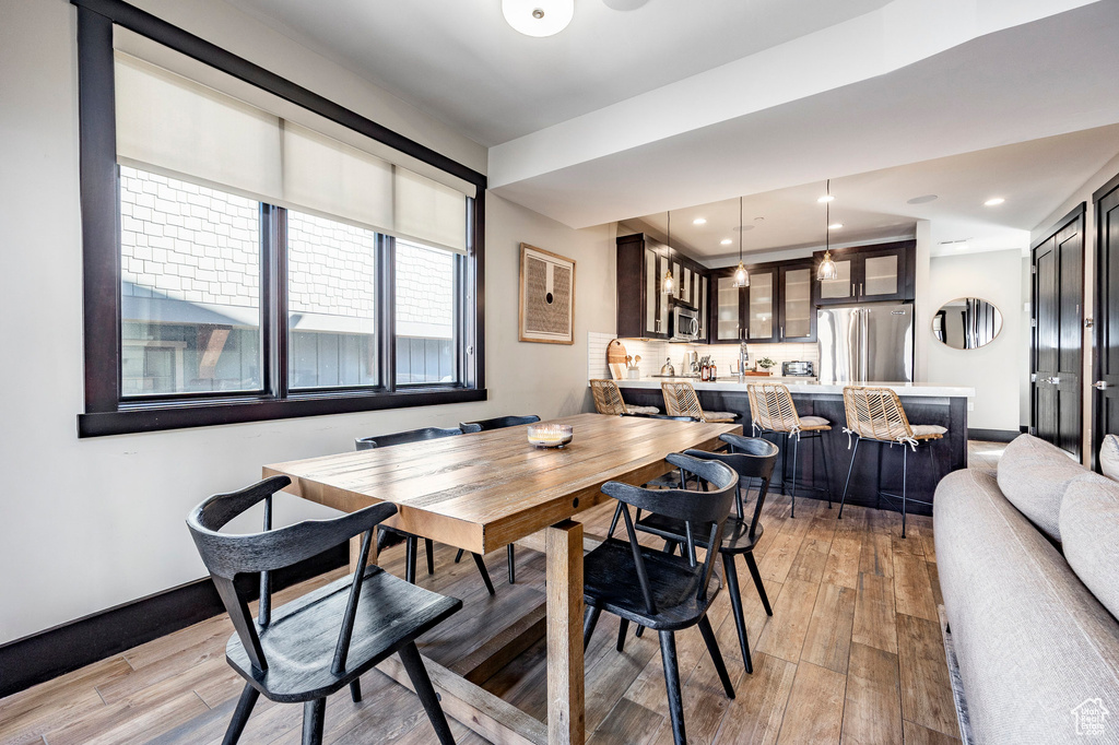 Dining area with light wood-style flooring, recessed lighting, and baseboards
