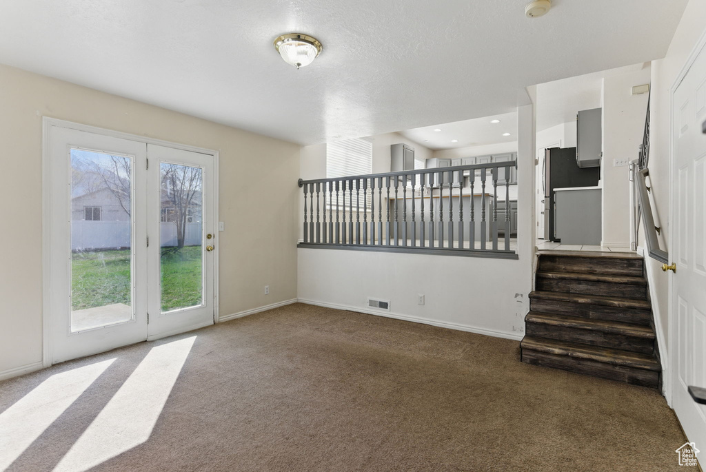 Unfurnished living room featuring visible vents, carpet, baseboards, stairs, and recessed lighting