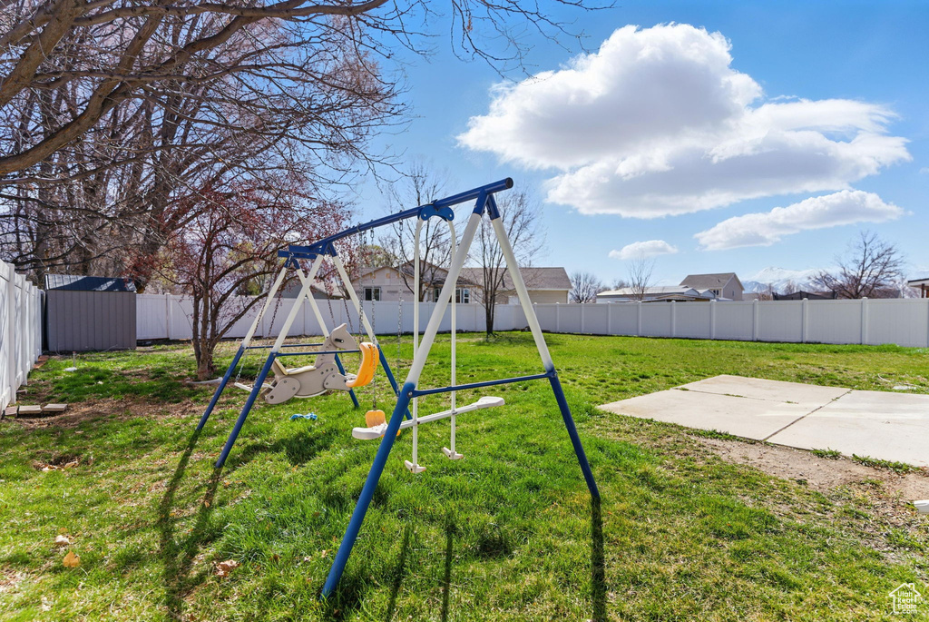 View of yard featuring a fenced backyard, a patio, and a playground
