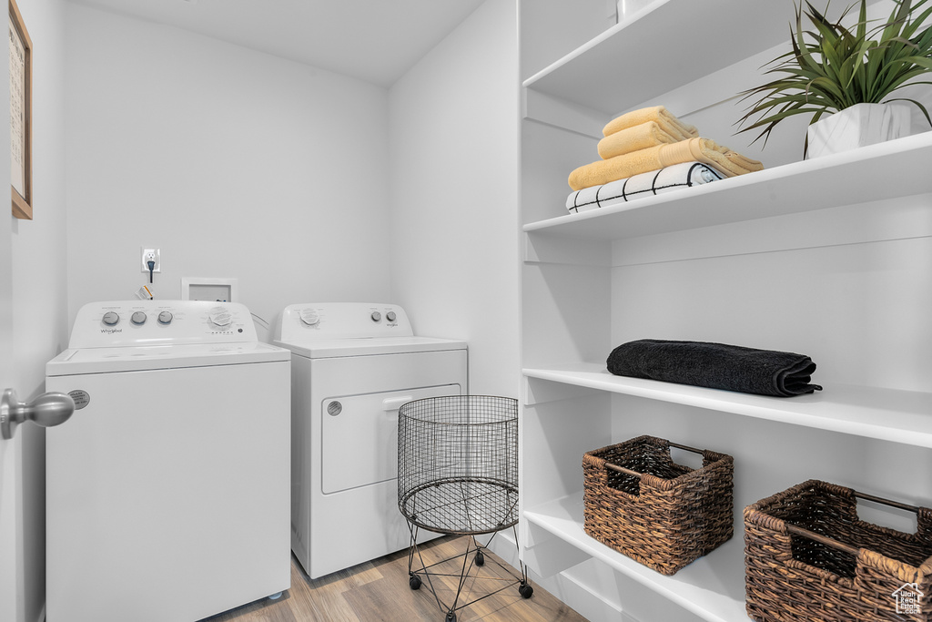 Laundry room with independent washer and dryer, light wood finished floors, and laundry area