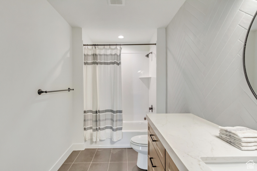 Full bath featuring baseboards, toilet, tile patterned floors, vanity, and shower / tub combo with curtain