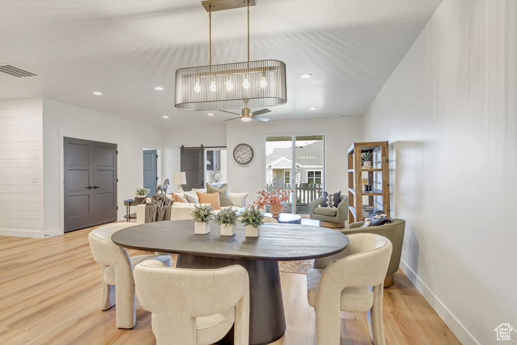 Dining room with a ceiling fan, baseboards, light wood-style floors, and visible vents