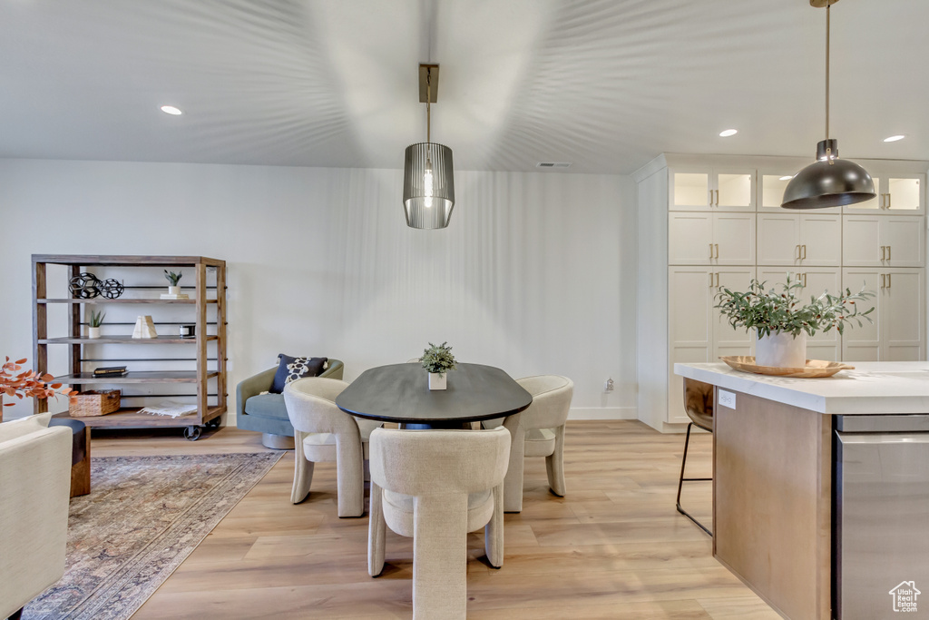 Dining room with light wood-style flooring and recessed lighting