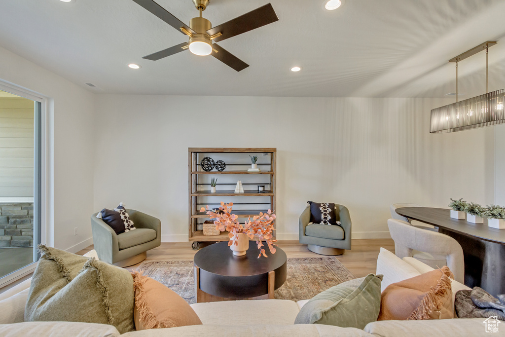 Living room with baseboards, wood finished floors, ceiling fan, and recessed lighting