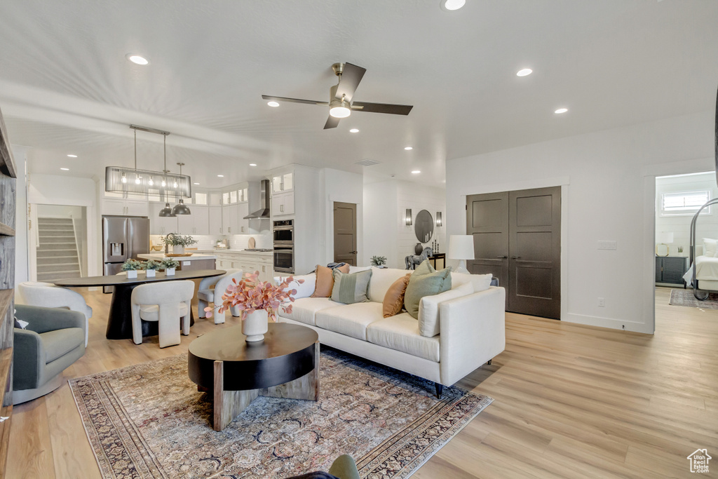 Living room with light wood-style flooring, recessed lighting, and a ceiling fan