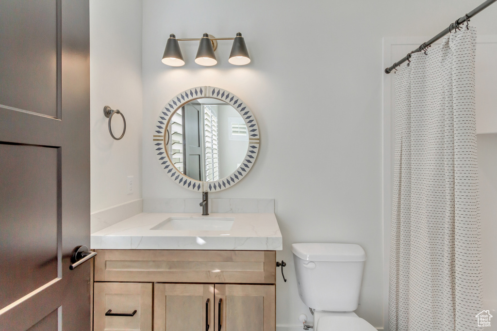 Bathroom with a shower with curtain, toilet, and vanity