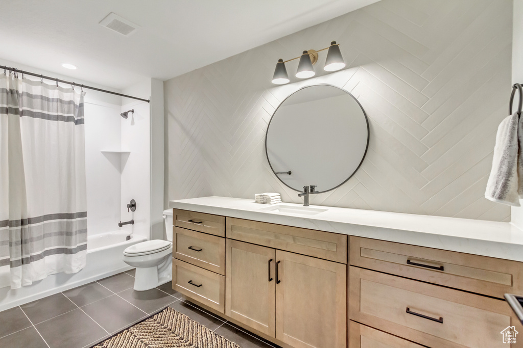 Bathroom featuring vanity, shower / tub combo, toilet, tile patterned floors, and visible vents