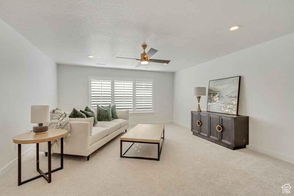 Living room with baseboards, carpet, and a ceiling fan
