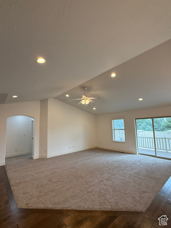 Empty room with vaulted ceiling, recessed lighting, baseboards, arched walkways, and a ceiling fan