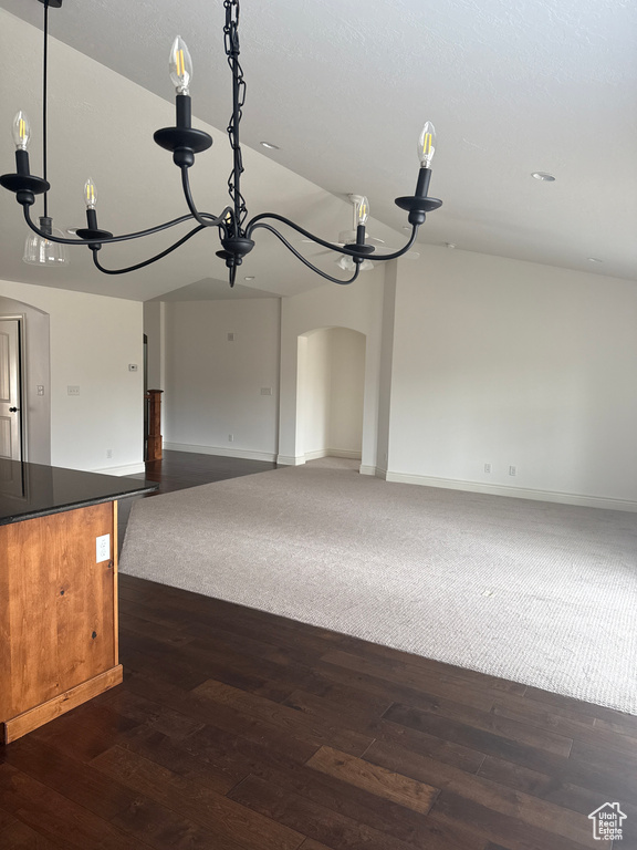 Interior space with an inviting chandelier, dark wood-style floors, and vaulted ceiling