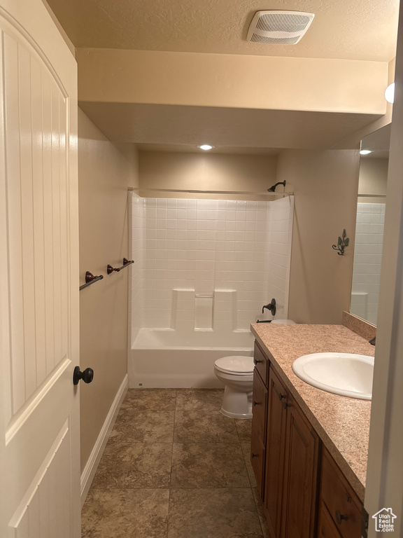 Bathroom featuring a textured ceiling, visible vents, toilet, vanity, and bathing tub / shower combination