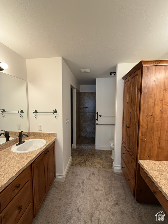 Full bathroom featuring baseboards, a textured ceiling, toilet, and vanity