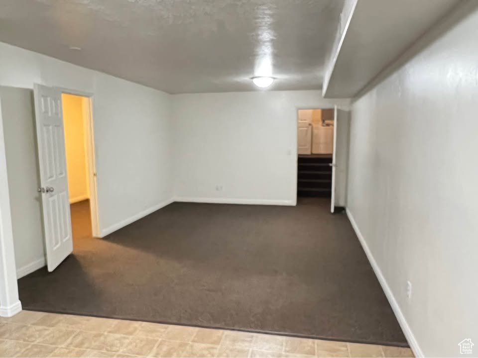 Carpeted spare room featuring baseboards