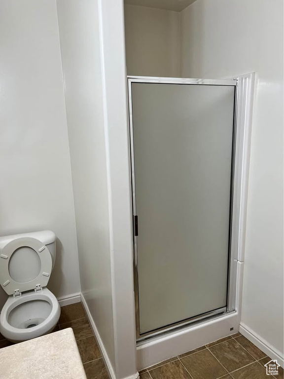 Full bathroom featuring a shower stall and tile patterned flooring