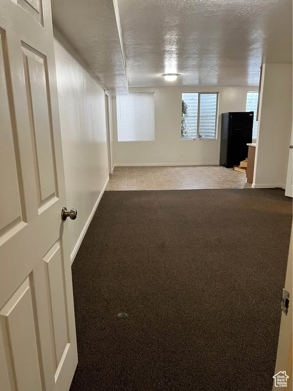 Empty room with carpet floors and a textured ceiling