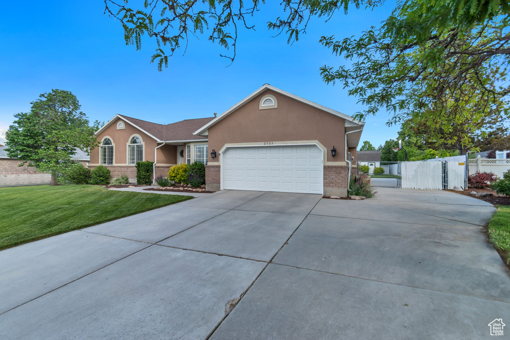Ranch-style house featuring stucco siding, concrete driveway, a garage, and brick siding