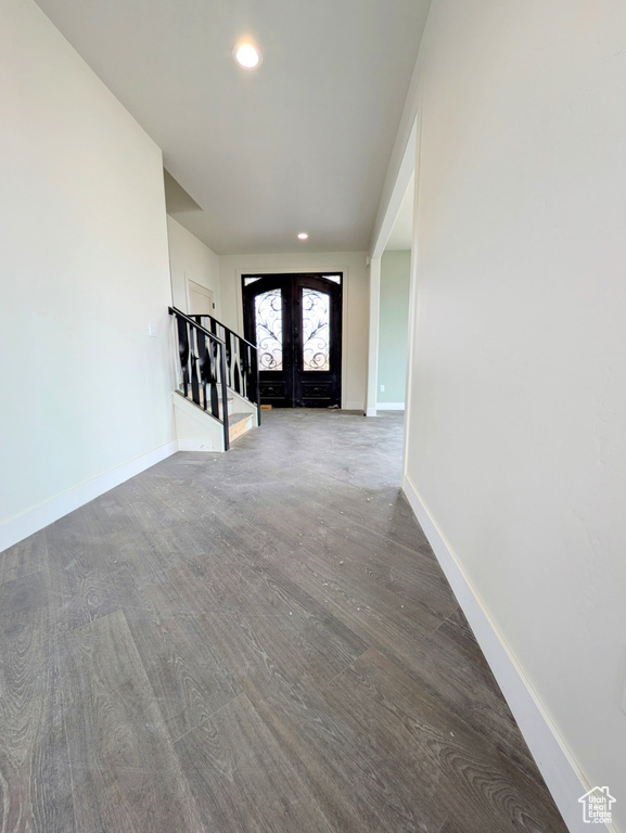 Foyer with stairs, french doors, wood finished floors, baseboards, and recessed lighting