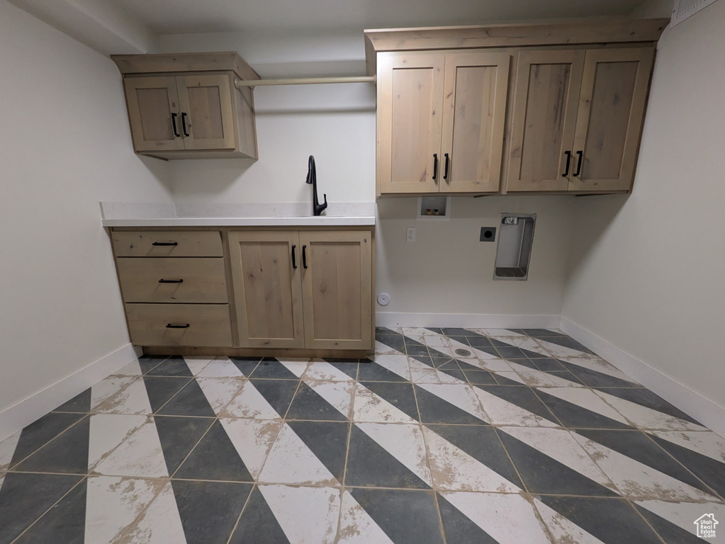 Kitchen with baseboards, a sink, and light brown cabinetry