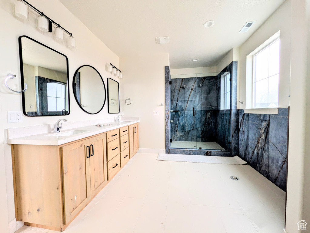 Bathroom with double vanity, a sink, a shower stall, and visible vents