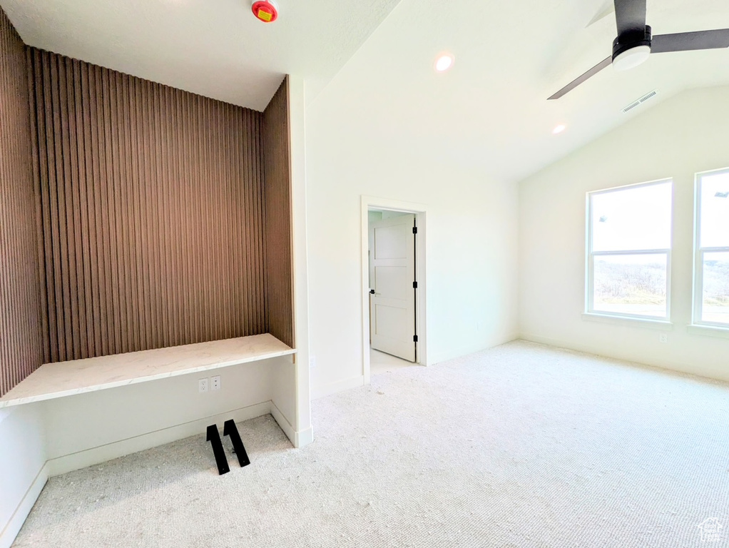 Interior space featuring visible vents, carpet, lofted ceiling, and ceiling fan