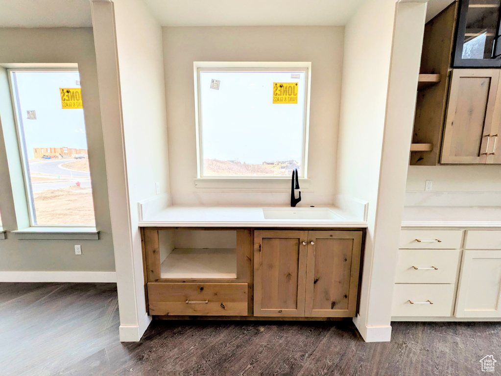 Bathroom featuring baseboards, wood finished floors, and vanity
