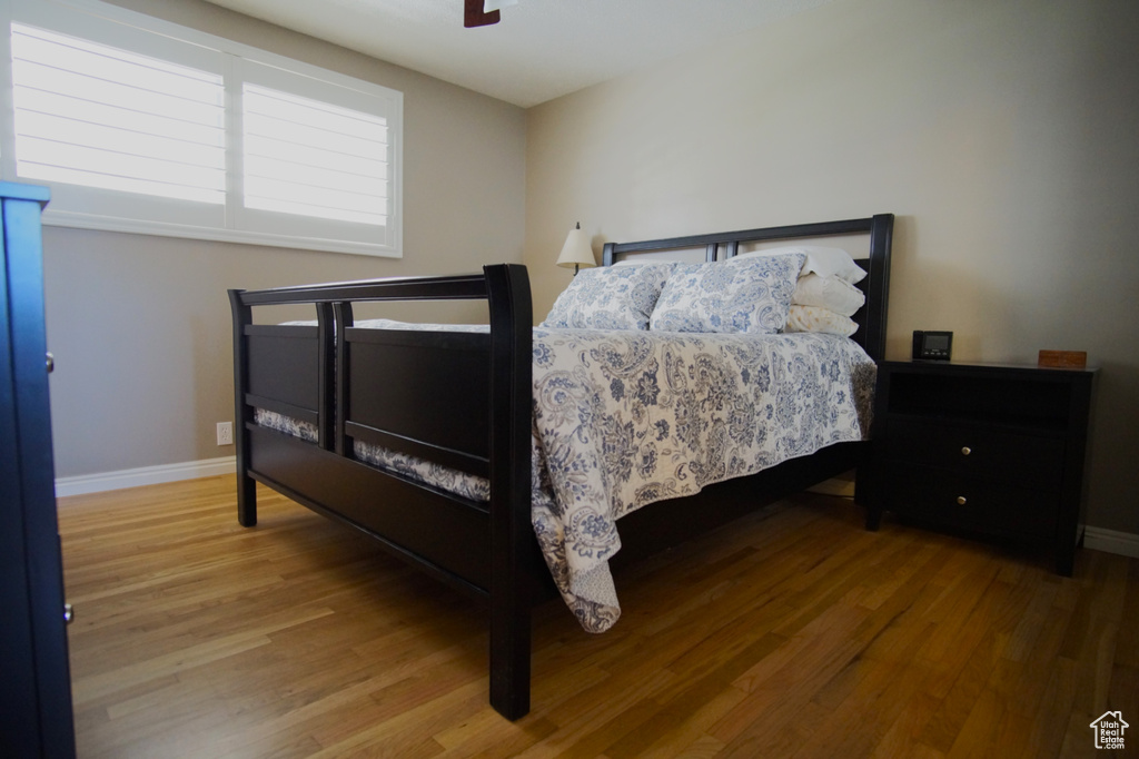 Bedroom with baseboards, wood finished floors, and a ceiling fan