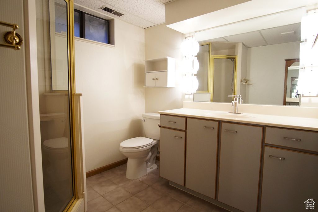 Full bathroom with vanity, toilet, tile patterned floors, a stall shower, and visible vents