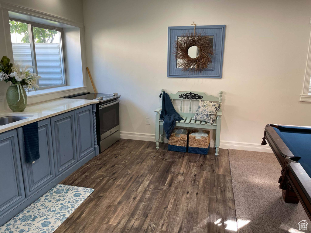 Interior space with baseboards, electric range, dark wood-style floors, and pool table