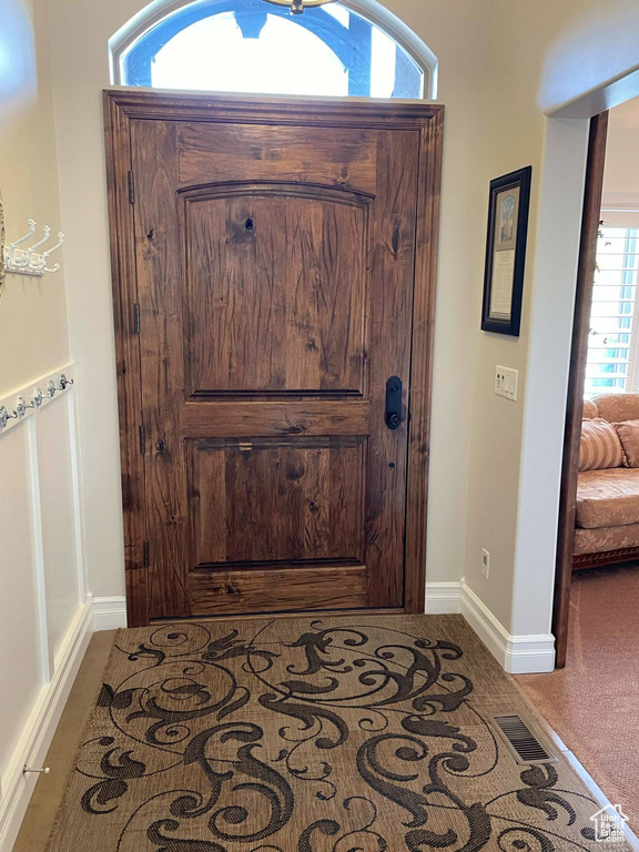 Carpeted foyer entrance featuring baseboards and visible vents