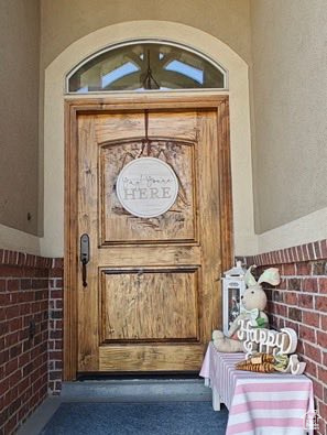 Property entrance with brick siding and stucco siding