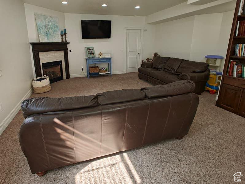 Living area with recessed lighting, baseboards, carpet, and a fireplace