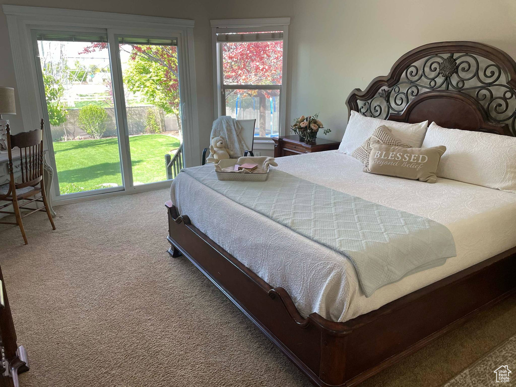 Carpeted bedroom featuring multiple windows and access to exterior