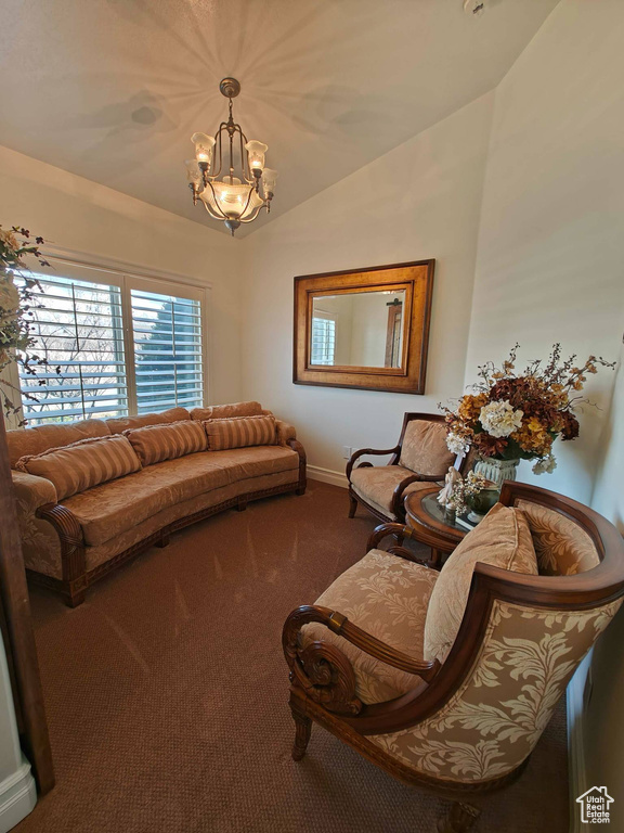 Carpeted living room featuring baseboards, a chandelier, and lofted ceiling