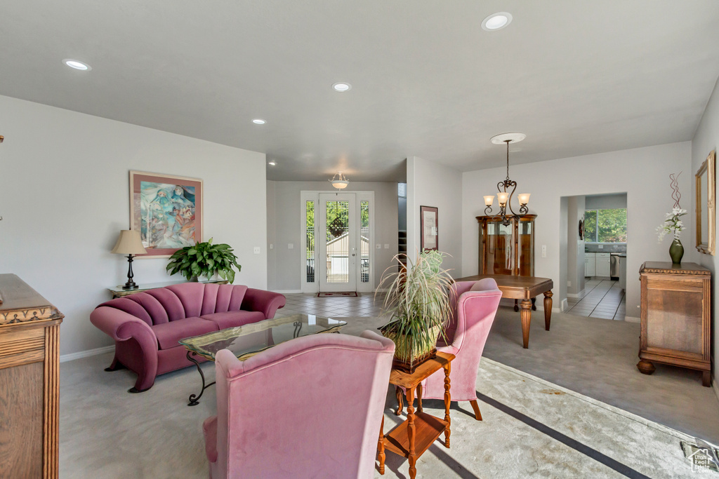 Living room with light carpet, baseboards, recessed lighting, and a chandelier
