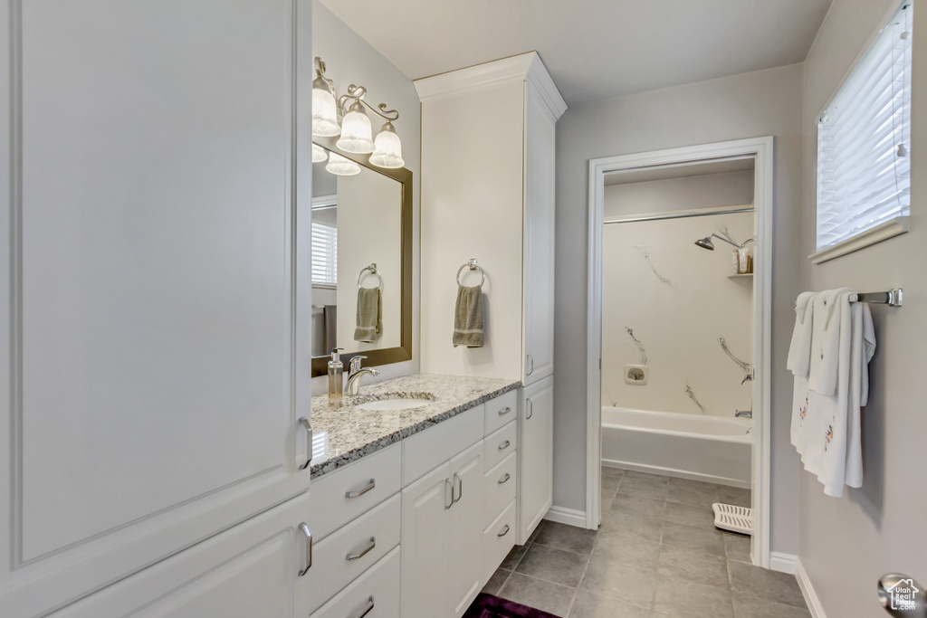 Full bath with shower / washtub combination, tile patterned flooring, vanity, and plenty of natural light