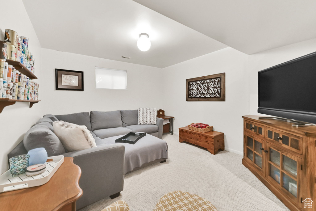Carpeted living area with baseboards and visible vents