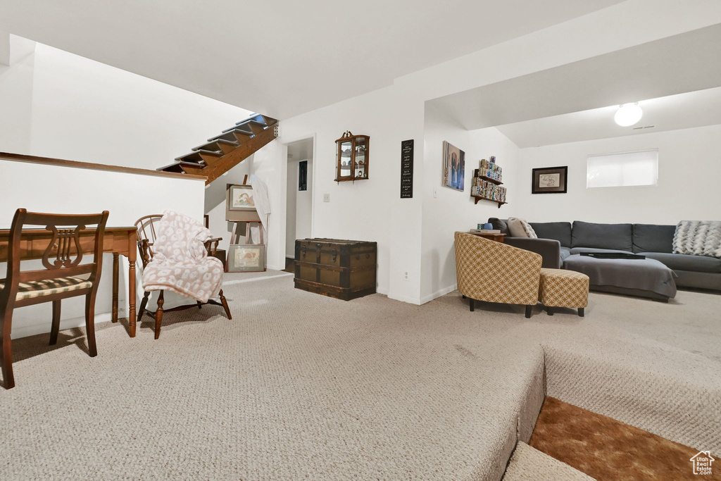 Carpeted living room with baseboards and stairs