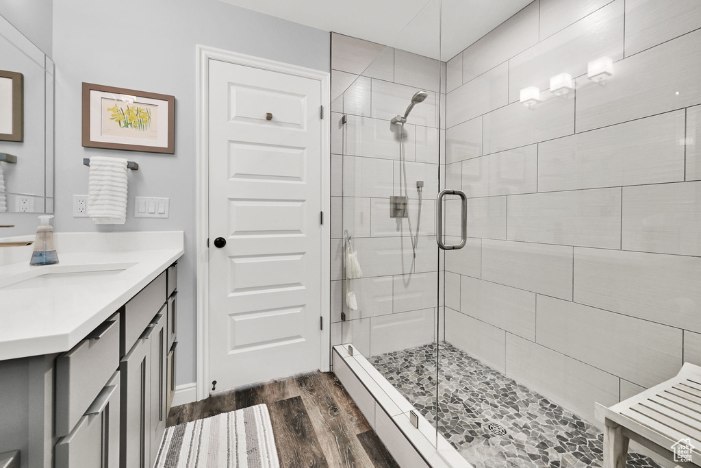 Bathroom featuring a stall shower, wood finished floors, and vanity