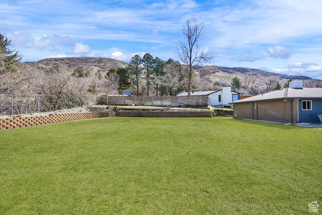 View of yard featuring a mountain view and fence