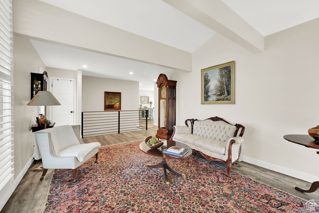 Living room featuring recessed lighting, vaulted ceiling with beams, baseboards, and wood finished floors