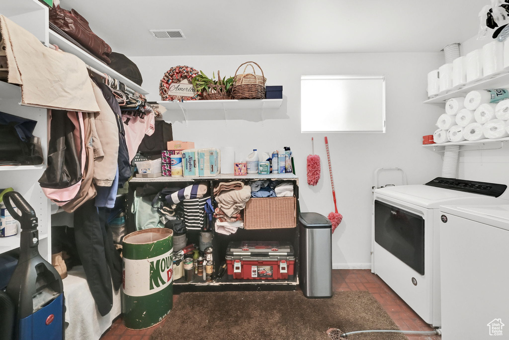 Washroom featuring visible vents, washing machine and clothes dryer, and laundry area