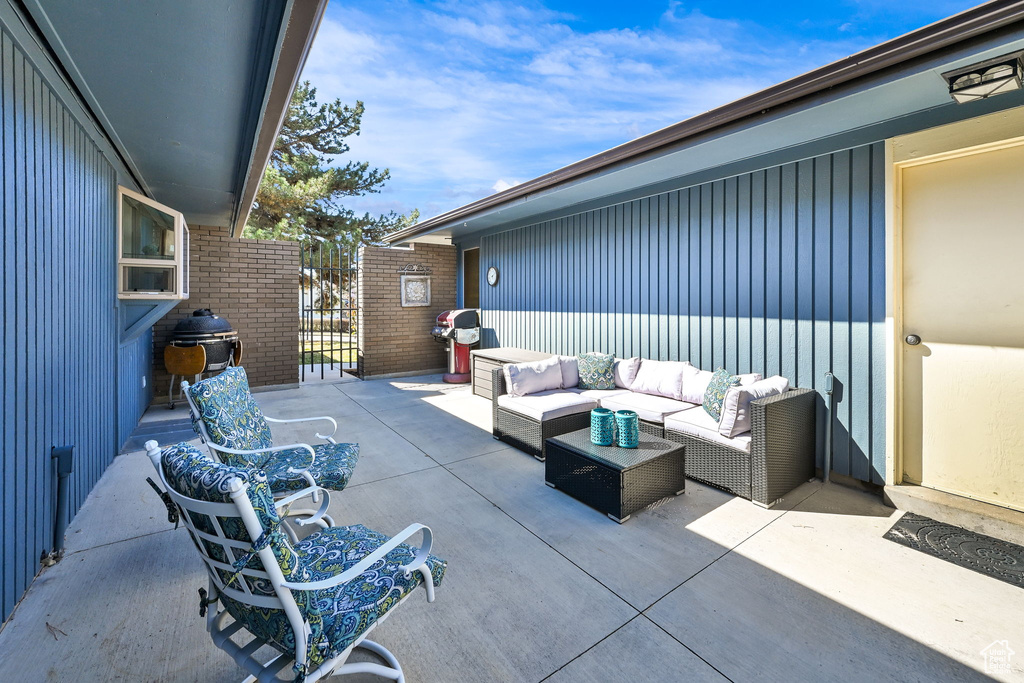 View of patio with an outdoor hangout area and a gate
