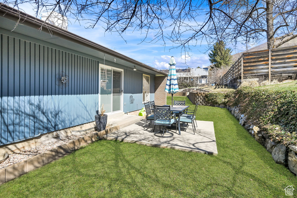 View of yard featuring fence and a patio area