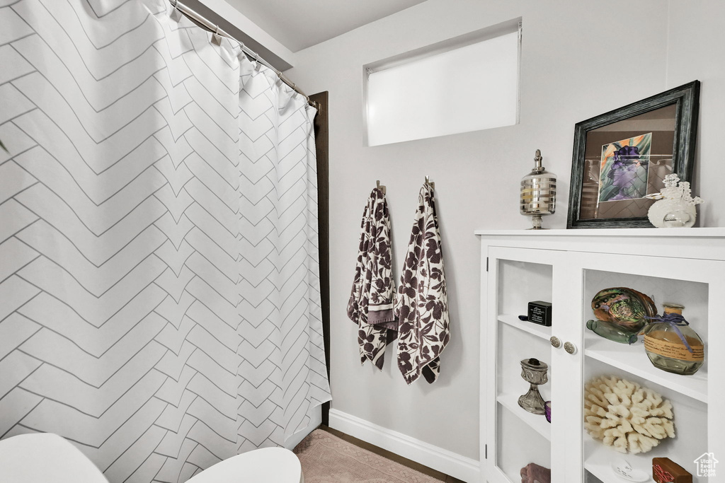 Full bathroom with a shower with curtain, toilet, and baseboards
