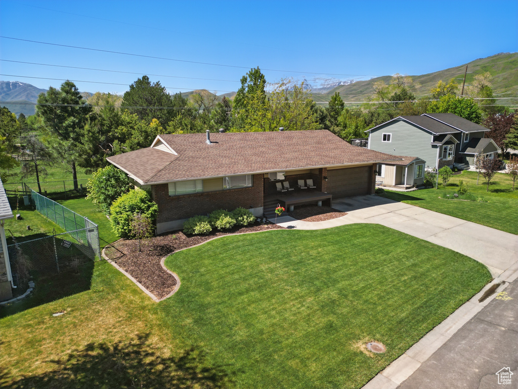 Ranch-style home featuring driveway, a garage, a mountain view, and covered porch